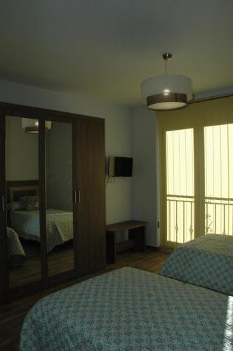 - une chambre avec 2 lits et un grand miroir dans l'établissement Canadina 2, à Morgovejo