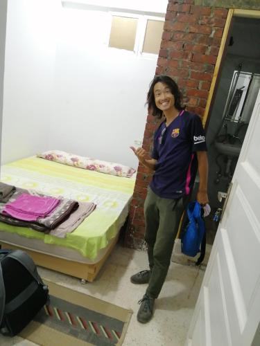 a woman standing next to a bed in a room at david hostel in Aswan