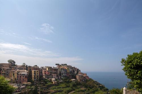 a town on a hill with the ocean in the background at Cecio 5 Terre Rooms in Corniglia