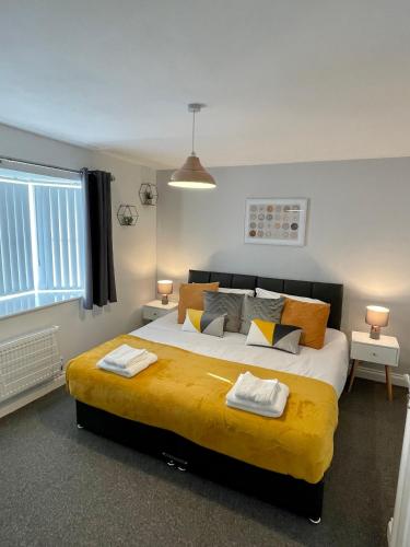 a bedroom with a large bed with two towels on it at The Shires in Nuneaton