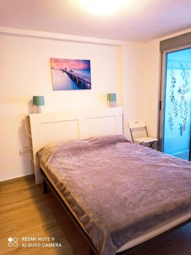 アリカンテにあるAitana playa San Juanのベッドルーム1室(壁に絵画が描かれたベッド1台付)