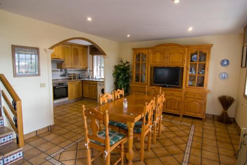 a kitchen with a table and chairs and a television at Playa de Cesantes in Pontevedra