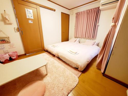 um pequeno quarto com uma cama e uma janela em Takaraboshi room 301 Sannomiya 10 min em Kobe