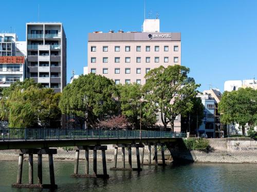 a bridge over the water in a city with buildings at EN HOTEL Hiroshima in Hiroshima