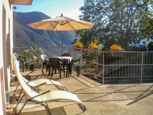 a patio with a table and an umbrella at Apartment Minú by Interhome in Porlezza
