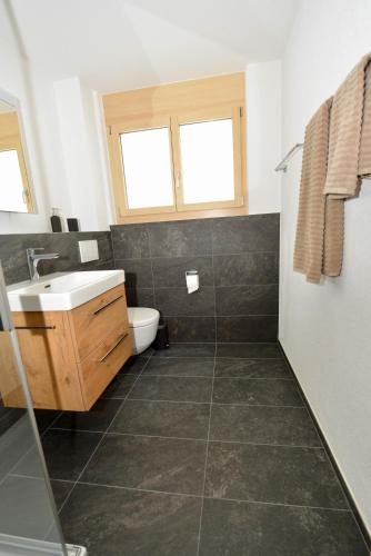 a bathroom with a sink and a toilet at Alpen-Park 2. Stock West in Riederalp