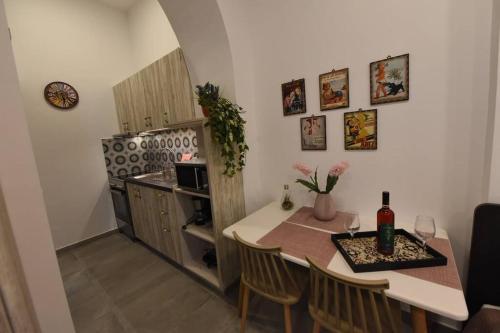 a small kitchen with a table and a refrigerator at Lolos' house in Rhodes Town