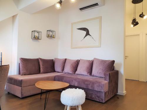 ein Wohnzimmer mit einem lila Sofa und einem Tisch in der Unterkunft Downtown apartment in Cetinje