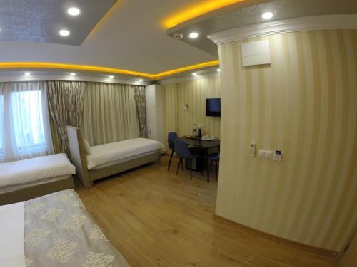 a hotel room with a bed and a desk with a table at Meydan Suites in Istanbul