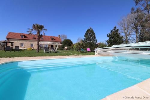 uma grande piscina azul em frente a uma casa em Domaine du clos henri em Essay