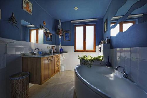 a blue bathroom with a tub and a sink at Casa con gran jardín y piscina en Cabarceno in Villanueva