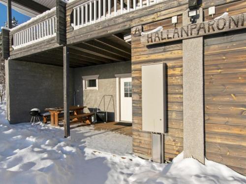 a building with a deck in the snow at Holiday Home Hallan paroni a paritalo by Interhome in Hyrynsalmi
