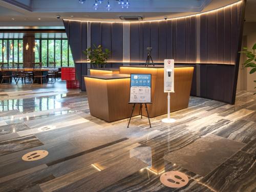 a lobby with a table and a sign on the floor at EN HOTEL Hiroshima in Hiroshima