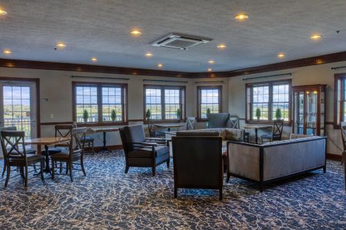 a waiting room with tables and chairs and windows at Carlisle Inn Walnut Creek in Walnut Creek