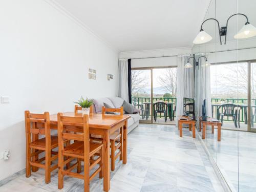 - un salon avec une table et des chaises en bois dans l'établissement Apartment Port Ducal-2 by Interhome, à Empuriabrava