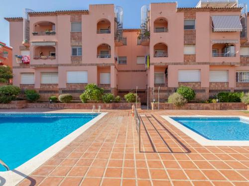 an apartment with a swimming pool in front of a building at Apartment Torrepuerto by Interhome in Torredembarra