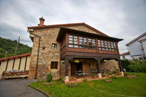 a large brick house with a balcony on the side of it at Posada Rural Ochohermanas in Las Fraguas