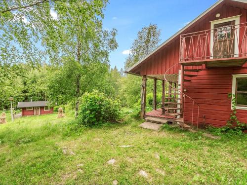 una casa roja con un balcón en el lateral. en Holiday Home Kesämäki by Interhome, en Hiukkajoki