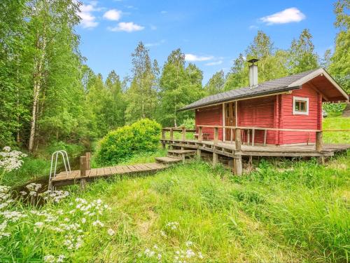 una cabaña roja en medio de un bosque en Holiday Home Kesämäki by Interhome, en Hiukkajoki