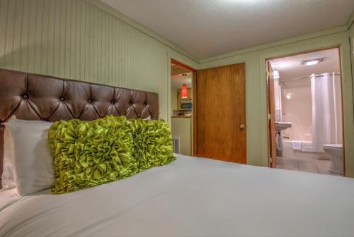 - un lit avec un oreiller vert dans l'établissement Linville Falls Lodge & Cottages, à Linville Falls