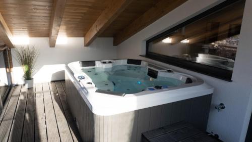 a jacuzzi tub in a room with a window at Sky Appartement in Großkirchheim