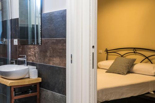 - une petite salle de bains avec un lavabo et un lit dans l'établissement 4 Balconi rooms-Elements B&B, à Lecce