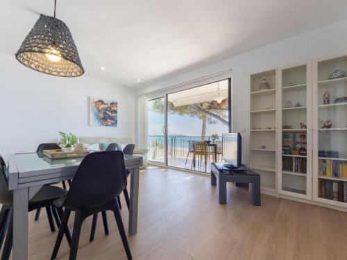 a living room with a dining room table and a view of the ocean at Apartment Reus Mediterraneo by Interhome in Vilafortuny