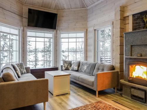 ein Wohnzimmer mit Couch und Kamin in der Unterkunft Holiday Home Villa tunturisopuli by Interhome in Raattama