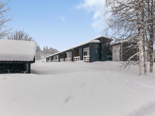 ein schneebedecktes Gebäude in einem Hof in der Unterkunft Holiday Home Skivillas paljakka 8- - 3mh by Interhome in Kotila