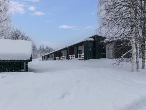a building covered in snow next to some trees at Holiday Home Skivillas paljakka 1- - 3 bedroom by Interhome in Kotila