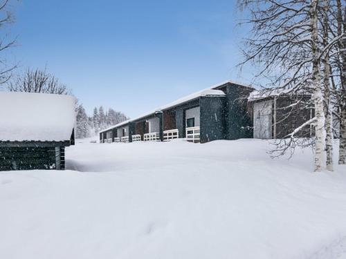 een gebouw bedekt met sneeuw naast een berg sneeuw bij Holiday Home Skivillas paljakka 5- - 3mh by Interhome in Kotila