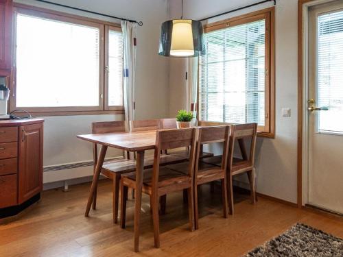 einen Esstisch und Stühle in einem Zimmer mit Fenstern in der Unterkunft Holiday Home Tahkon klubitie 2 a by Interhome in Tahkovuori