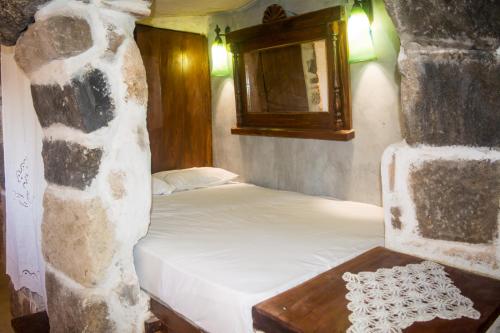 a small bedroom with a bed and a mirror at Palaiokastro Traditional House in Mandrákion