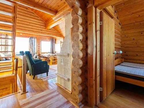 Blockhütte mit einem Bett und einem Wohnzimmer in der Unterkunft Holiday Home Alppimaja b paritalo by Interhome in Hyrynsalmi