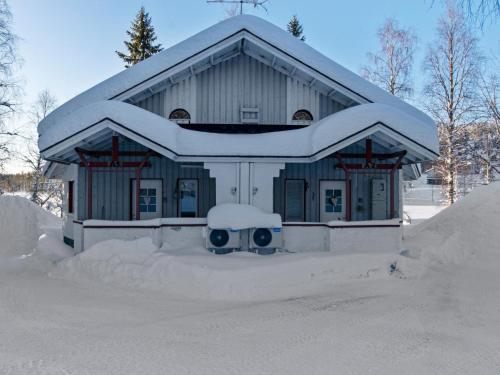une maison recouverte de neige devant dans l'établissement Holiday Home Hallantytär a1 paritalo by Interhome, à Hyrynsalmi