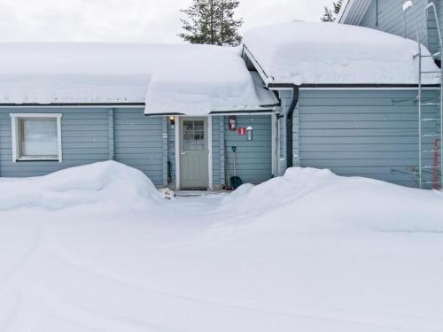 une maison recouverte de neige avec un tas de neige dans l'établissement Holiday Home Paljakan pirtit a3 by Interhome, à Kotila