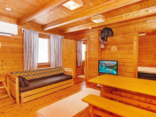 a living room with a bench and a tv in a cabin at Holiday Home Lohiukko by Interhome in Kotila
