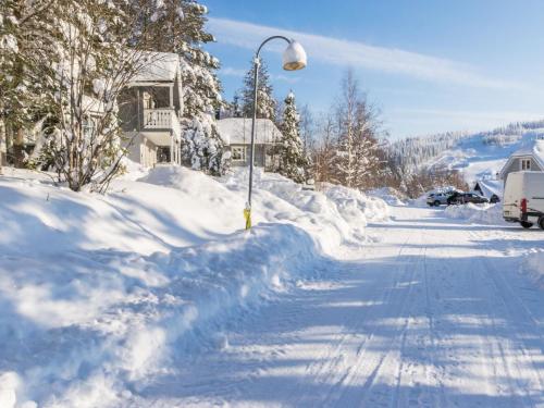 een straat bedekt met sneeuw met een straatlicht bij Holiday Home Gasthalla b paritalo by Interhome in Hyrynsalmi