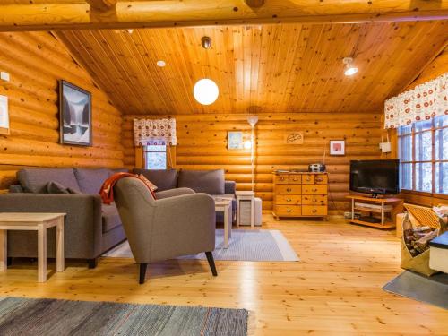 a living room with a couch and a tv at Holiday Home Kultapaljakka 4 by Interhome in Kotila