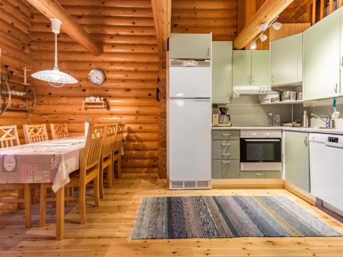 a kitchen with green cabinets and a table and chairs at Holiday Home Kultapaljakka 4 by Interhome in Kotila