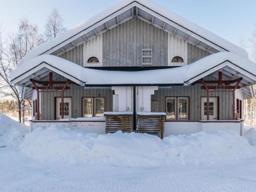 dom pokryty śniegiem z kupą śniegu w obiekcie Holiday Home Hallantytär b4 paritalo by Interhome w mieście Hyrynsalmi