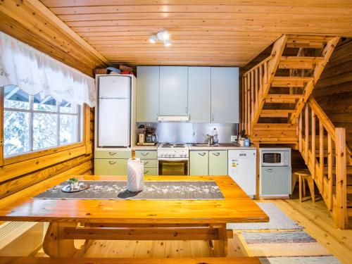 eine Küche mit einem Holztisch in einer Hütte in der Unterkunft Holiday Home Metsätähti by Interhome in Kotila