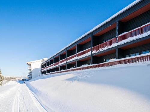 ein Gebäude mit Schnee auf dem Boden daneben. in der Unterkunft Holiday Home Skivillas 61 ukkohalla - b4 by Interhome in Hyrynsalmi