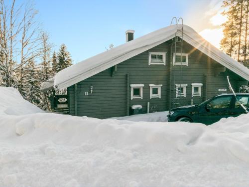 a house with a pile of snow in front of it at Holiday Home Ukkoloma b paritalo by Interhome in Hyrynsalmi