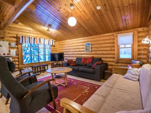a living room with a couch and a tv in a cabin at Holiday Home Kultapaljakka 3 by Interhome in Kotila
