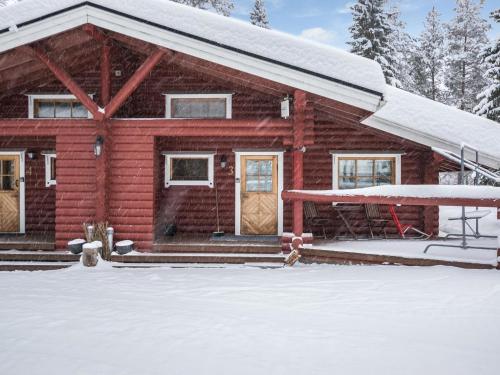 domek z bali i śniegiem na ganku w obiekcie Holiday Home Kultapaljakka 3 by Interhome w mieście Kotila