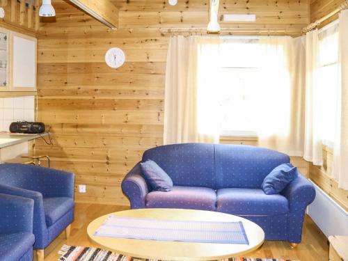 a living room with a blue couch and a table at Holiday Home Miilumaja a2 by Interhome in Kotila