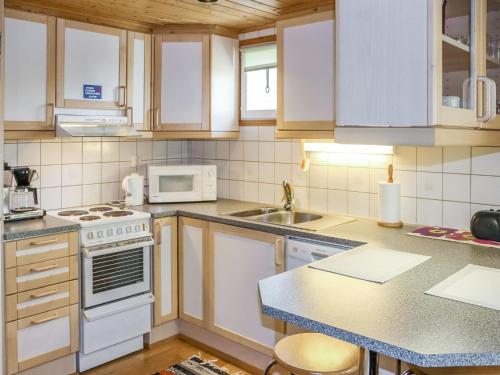 - une cuisine avec des appareils électroménagers blancs et un comptoir dans l'établissement Holiday Home Miilumaja a2 by Interhome, à Kotila