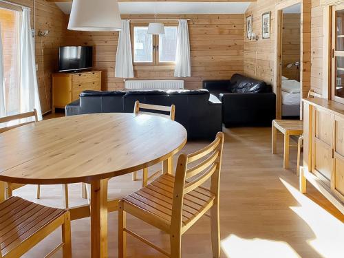 een woonkamer met een tafel en een bank bij Holiday Home De Brenkberg in Schinveld