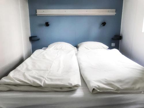 Duas almofadas brancas sentadas numa cama num quarto em Holiday Home De Brenkberg-1 em Schinveld